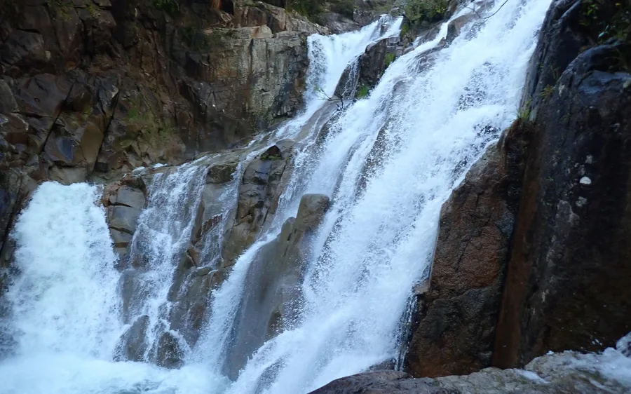 White water falling over granite boulders in a rainforest gorge